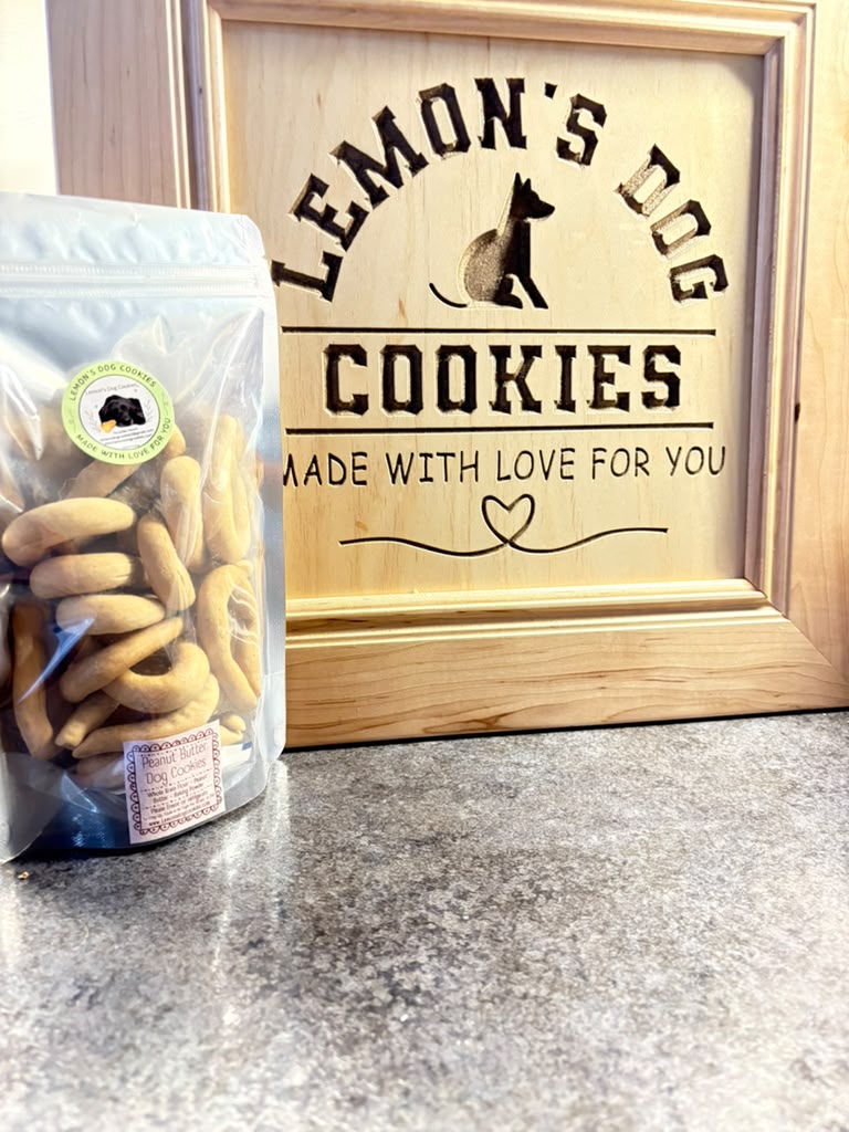 The Mini Beg-Al 16-Pack in its silver bag beside the engraved Lemon's Dog Cookies sign